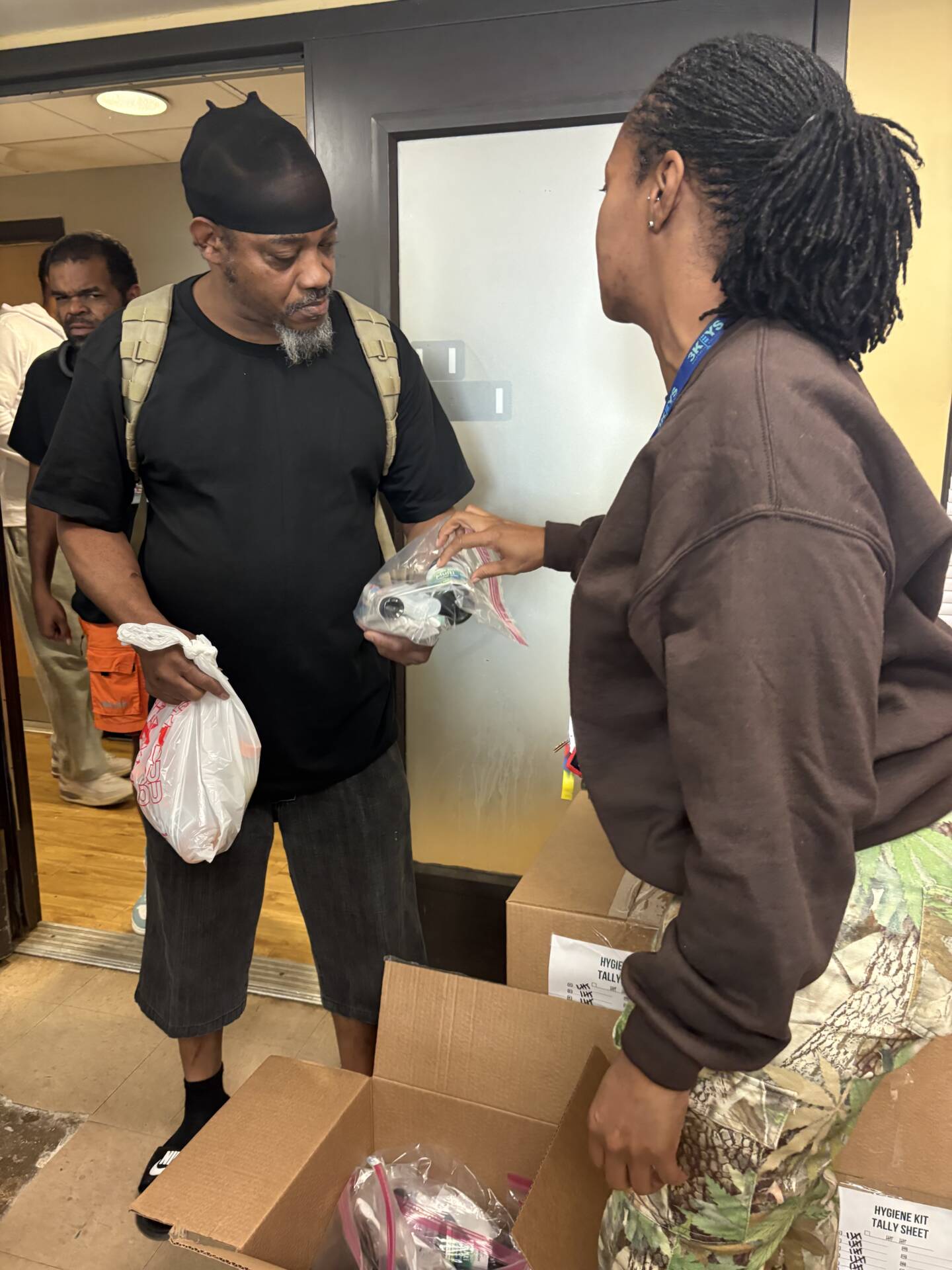 3Keys staff members hand out hygiene kits to residents of Welcome House, a permanent supportive housing apartment complex for formerly homeless individuals