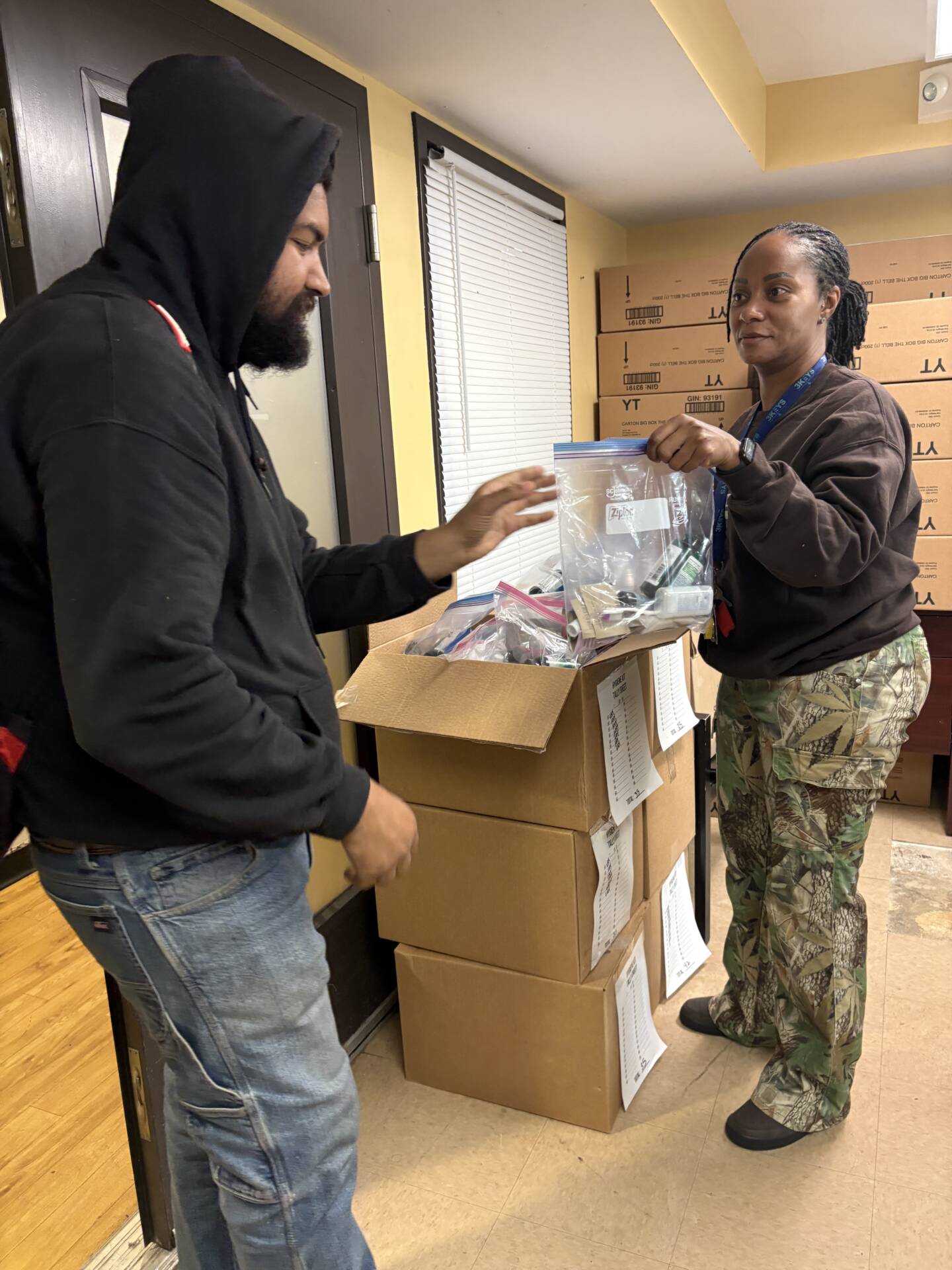 3Keys staff members hand out hygiene kits to residents of Welcome House, a permanent supportive housing apartment complex for formerly homeless individuals
