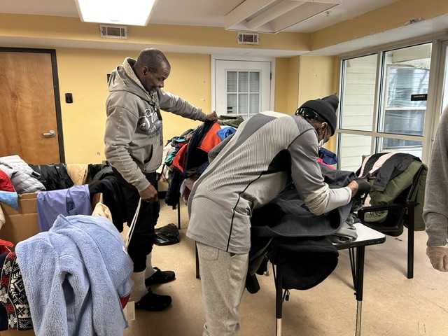 3Keys residents look through donated coats laid out on tables at Welcome House in Atlanta.