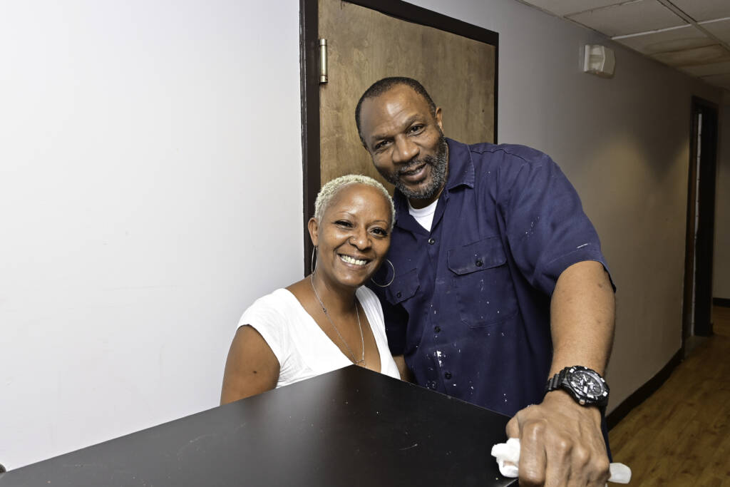 Tyson standing at the front desk of Welcome House with a gentleman.