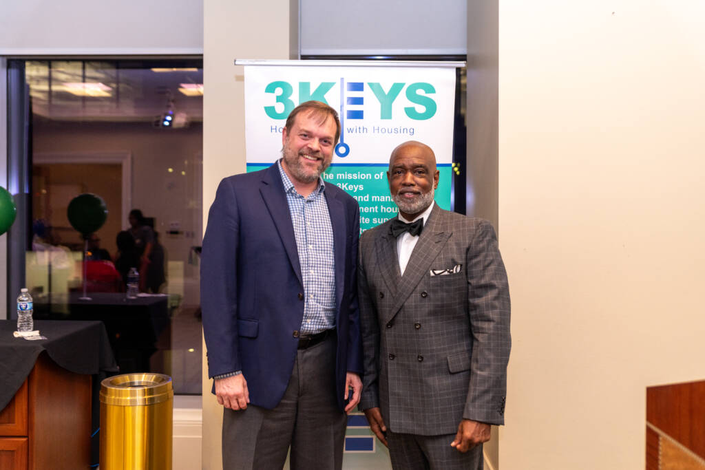 Jon Toppen and Scott Walker are pictured in front of a 3Keys roll-up banner at Cheers for a Cause, 3Keys' annual fundraiser, in 2025.