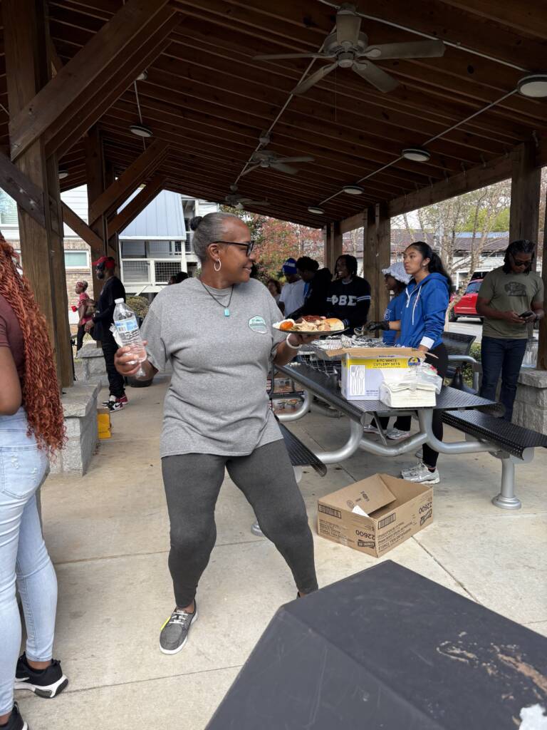 A woman dances after receiving food during H2H's Annual Feed the Hungry event at the Phoenix House.