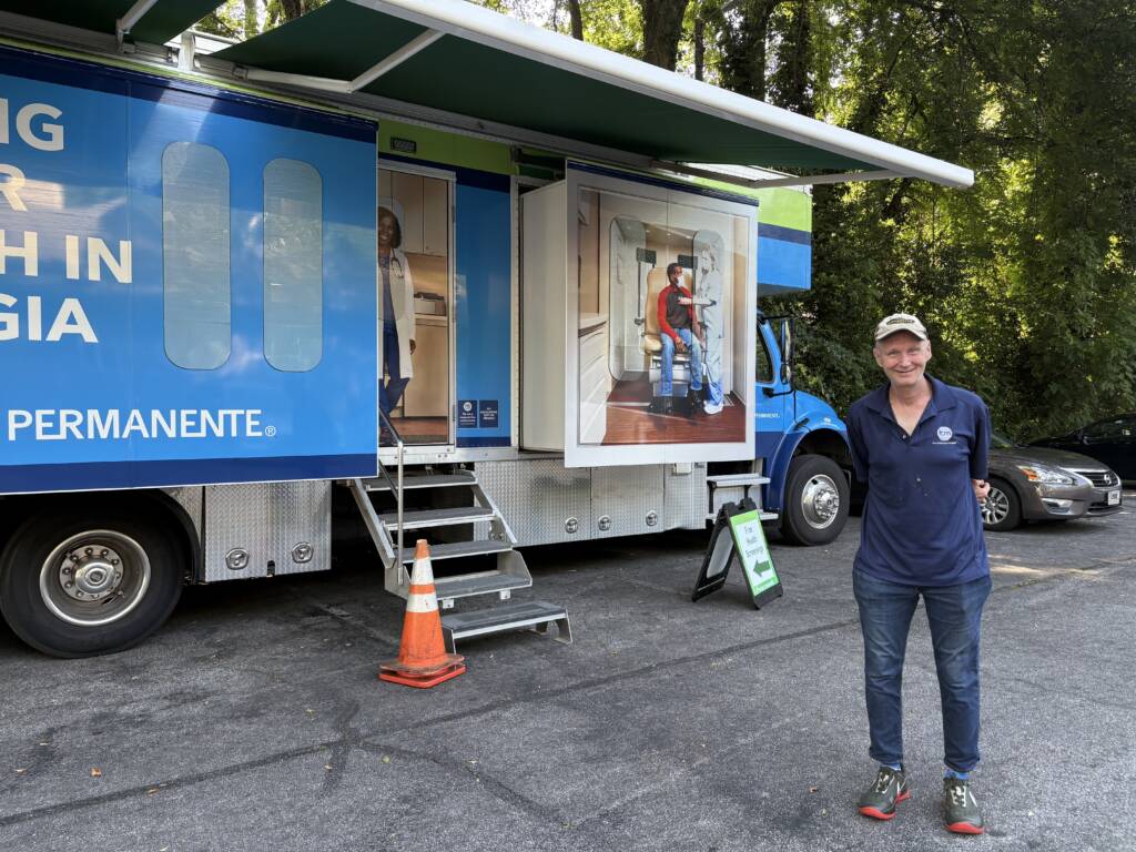 A resident of a 3Keys apartment stands in front of the Kaiser Permanente Mobile Health Van in Atlanta, Georgia.