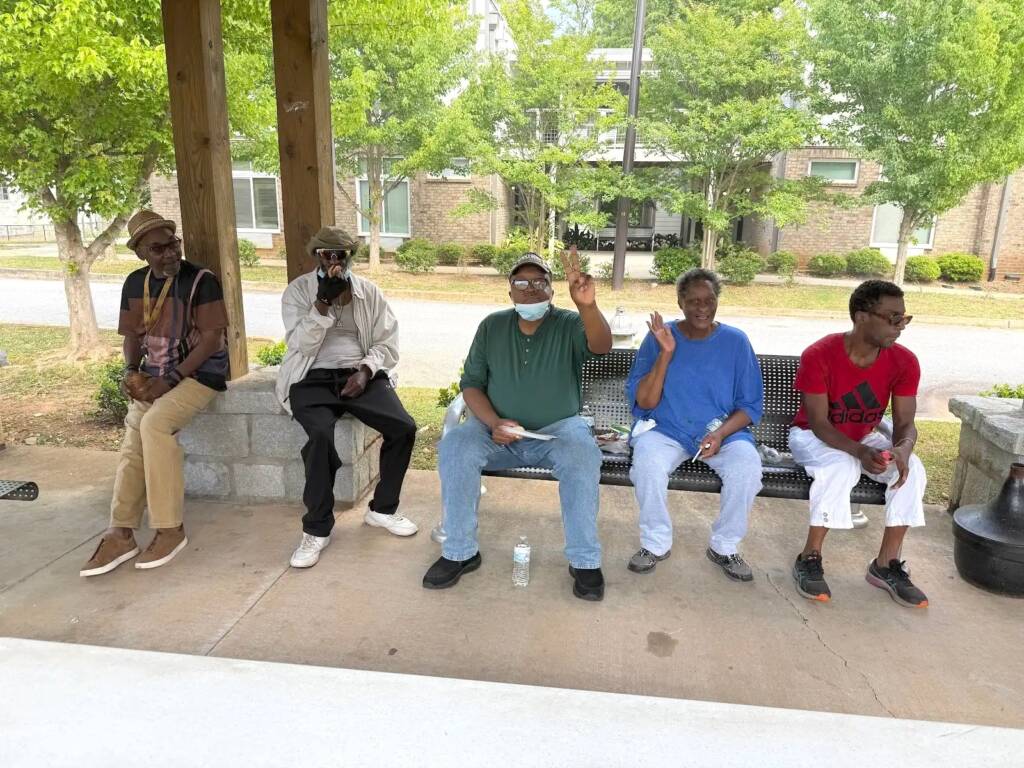 Residents gather for a BBQ under the pavilion at Phoenix House in Atlanta