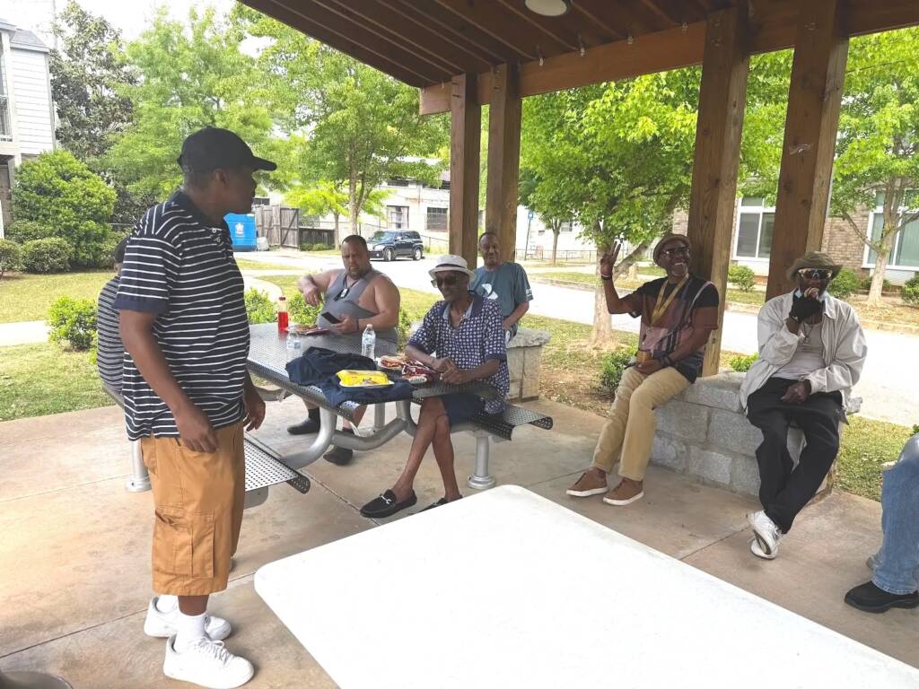 Residents gather for a BBQ under the pavilion at Phoenix House in Atlanta