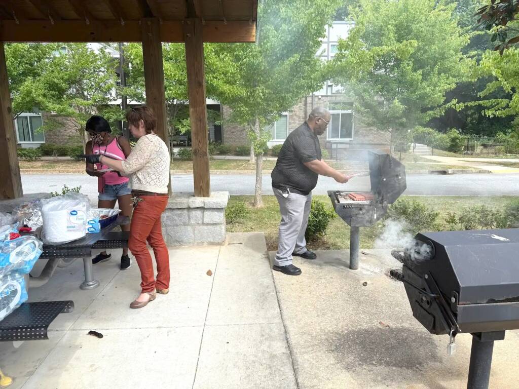Residents gather for a BBQ under the pavilion at Phoenix House in Atlanta